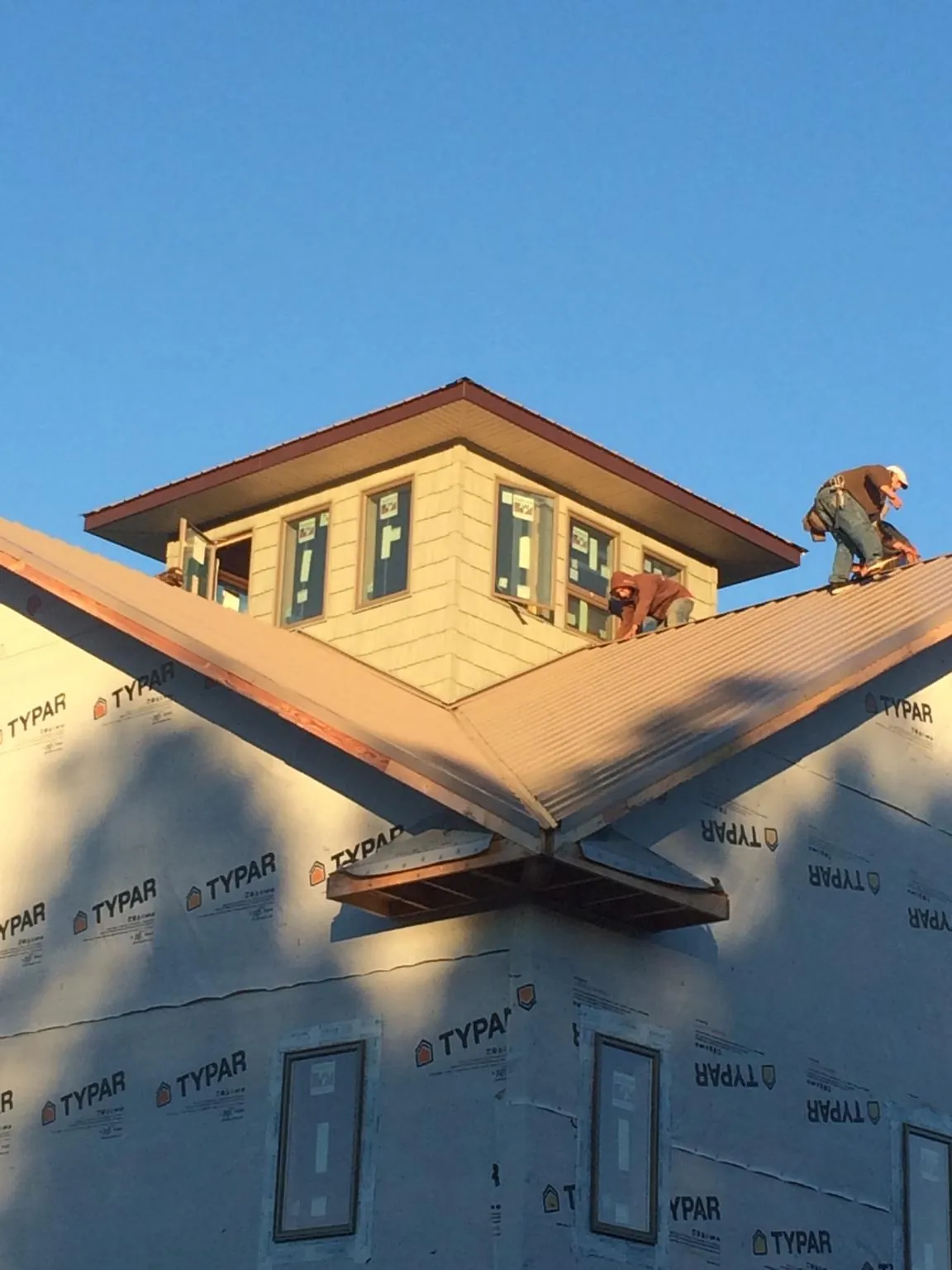 Roofers working around a rooftop cupola on a new metal roof at sunset — Roof Waterproofing in Venice by Roofing Brothers